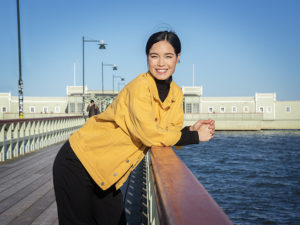 Ida On lutar sig mot ett räcke med vatten och kallbadhuset i Malmö i bakgrunden