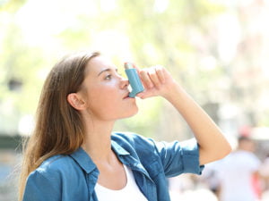 Kvinna använder inhalator utomhus